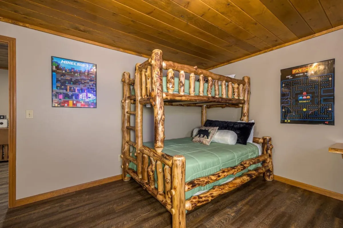 A bunk bed setup with Minecraft artwork and a Pac-Man poster, set in a fun, adventurous space that encourages play, imagination, and gaming marathons. The decor and layout make it clear this is a space for younger gamers or family fun.