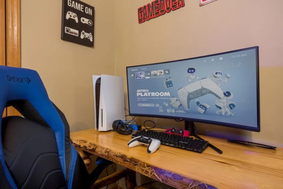 This image shows a vibrant gaming setup featuring a gaming monitor, gaming chair, console, keyboard, and game controller. The mood is energetic, with an emphasis on immersive gaming and social play. The space is clearly dedicated to competitive and group gaming experiences.